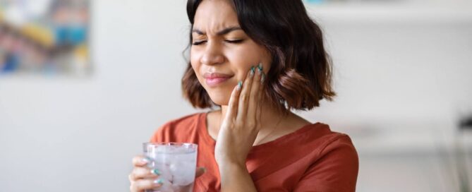 Woman holding cheek with toothache