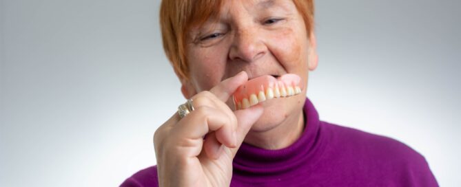 woman holding dentures